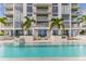 Stunning condominium pool with lounge chairs, umbrellas, and lush landscaping with palm trees at 301 1St S St # 1206, St Petersburg, FL 33701