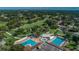An aerial view captures multiple pools and a golf course surrounded by trees and residential areas at 3021 Countryside Blvd # 26A, Clearwater, FL 33761