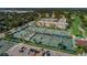 Aerial view of a resort community with multiple tennis courts and tropical landscaping near condos at 3021 Countryside Blvd # 26A, Clearwater, FL 33761