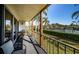 Relaxing balcony with outdoor seating overlooking a vibrant green landscape and nearby tennis courts at 3021 Countryside Blvd # 26A, Clearwater, FL 33761