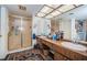 Well-lit bathroom boasts a double sink vanity, large mirror, and enclosed shower with stylish fixtures at 3021 Countryside Blvd # 26A, Clearwater, FL 33761