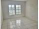 Bright bedroom featuring tile floors and a large window with plantation shutters at 3021 Countryside Blvd # 26A, Clearwater, FL 33761