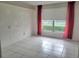 Simple bedroom with tile floors, a window with red curtains, and bright natural light at 3021 Countryside Blvd # 26A, Clearwater, FL 33761