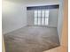 Spacious bedroom featuring carpeted floors, modern window, and ensuite bath at 3021 Countryside Blvd # 26A, Clearwater, FL 33761