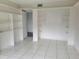 Bedroom featuring tile floors, open closet with shelves, and access to ensuite bath at 3021 Countryside Blvd # 26A, Clearwater, FL 33761