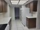 Well-lit kitchen features white appliances, wood cabinets, and white countertops at 3021 Countryside Blvd # 26A, Clearwater, FL 33761