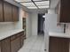 Bright kitchen features white appliances, wood cabinets, and tiled flooring at 3021 Countryside Blvd # 26A, Clearwater, FL 33761