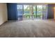 Open living room with a large sliding glass door to patio overlooking tennis court at 3021 Countryside Blvd # 26A, Clearwater, FL 33761