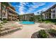 Relaxing community pool with plentiful lounge chairs and well-maintained landscaping and palm trees at 3021 Countryside Blvd # 26A, Clearwater, FL 33761