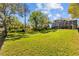 Large backyard showcasing a meticulously maintained lawn with mature trees at 3114 Bluff Blvd, Holiday, FL 34691