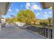 Outdoor balcony with white railings showcases tree top views and a blue sky at 3114 Bluff Blvd, Holiday, FL 34691