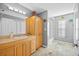 Bright bathroom with a vanity, storage cabinet, and a glass-enclosed shower at 3114 Bluff Blvd, Holiday, FL 34691