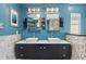 Modern bathroom featuring double sinks, sleek black cabinetry, and stylish tile work at 3114 Bluff Blvd, Holiday, FL 34691