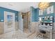 Bathroom featuring a glass block shower, chandelier, and vanity area with balcony access at 3114 Bluff Blvd, Holiday, FL 34691