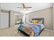 Bedroom featuring a ceiling fan, double mirrored closet, and a cozy bed with decorative pillows at 3114 Bluff Blvd, Holiday, FL 34691