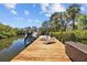 Beautiful waterfront property featuring a boat lift, sun loungers, and storage on a private wooden dock at 3114 Bluff Blvd, Holiday, FL 34691