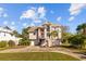 Inviting two-story home with a front-facing two-car garage, landscaped yard, and charming balcony at 3114 Bluff Blvd, Holiday, FL 34691