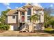 Inviting two-story home with dual garages, white staircase, red door, and balcony at 3114 Bluff Blvd, Holiday, FL 34691