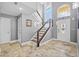 Spacious foyer featuring tile floors, high ceilings, staircase, and a frosted glass front door at 3114 Bluff Blvd, Holiday, FL 34691