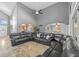 Bright living room with tile floors, high ceilings, a large dark leather sofa and an archway leading to kitchen at 3114 Bluff Blvd, Holiday, FL 34691