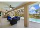 Screened outdoor pool area with comfortable seating, ceiling fans, and lush views at 3114 Bluff Blvd, Holiday, FL 34691