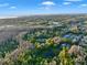 Expansive aerial view showcasing a luxurious home nestled amidst lush greenery and a serene pond at 3198 Thatcher Ln, Tarpon Springs, FL 34688