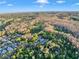 Aerial view showing the location of the property surrounded by a wooded area, lake, and neighborhood at 3198 Thatcher Ln, Tarpon Springs, FL 34688