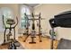 Home gym featuring weight machines, a treadmill, elliptical, and wood flooring at 3198 Thatcher Ln, Tarpon Springs, FL 34688