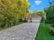Charming exterior featuring a sprawling paver driveway and lush landscaping at 3198 Thatcher Ln, Tarpon Springs, FL 34688