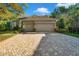 Attractive single-Gathering home featuring a spacious three-car garage and brick paver driveway at 3198 Thatcher Ln, Tarpon Springs, FL 34688