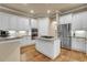 Kitchen featuring white cabinets, stainless appliances, granite counters and a kitchen island at 3198 Thatcher Ln, Tarpon Springs, FL 34688