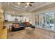 Living room showcasing a leather sectional couch, wood floors, and sliding glass doors at 3198 Thatcher Ln, Tarpon Springs, FL 34688