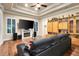 Living room with wood floors, built-in storage, fireplace, and a large leather couch at 3198 Thatcher Ln, Tarpon Springs, FL 34688