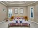 Bright bedroom with tray ceiling, carpet, and large windows with plantation shutters at 3198 Thatcher Ln, Tarpon Springs, FL 34688