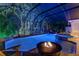 Backyard pool and hot tub area featuring a fire pit and lush greenery at 3198 Thatcher Ln, Tarpon Springs, FL 34688