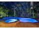 Inviting in-ground pool with integrated spa, surrounded by brick pavers in a screened enclosure and lush landscaping at 3198 Thatcher Ln, Tarpon Springs, FL 34688