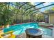A beautiful screened-in pool and spa surrounded by brick pavers and lush trees at 3198 Thatcher Ln, Tarpon Springs, FL 34688
