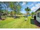 Spacious backyard with lush green grass and mature trees leading to a serene pond at 3212 Mcmath Dr, Palm Harbor, FL 34684