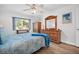 Inviting bedroom with wood floors, dresser, ample natural light, and a decorative bench at 3212 Mcmath Dr, Palm Harbor, FL 34684