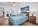 Well-lit bedroom featuring wood floors, a decorative bed, and coordinated furnishings at 3212 Mcmath Dr, Palm Harbor, FL 34684