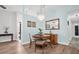 Cozy dining room featuring wood floors, table, chairs, stylish chandelier, and a mirrored accent wall at 3212 Mcmath Dr, Palm Harbor, FL 34684