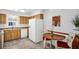 Eat-in kitchen with wooden cabinets, white appliances, and a dining table at 3212 Mcmath Dr, Palm Harbor, FL 34684