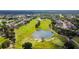 Stunning aerial view of lush golf course with water feature and mature trees within the community at 3215 Banyan Hill Ln, Land O Lakes, FL 34639
