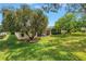 Expansive backyard with a screened patio surrounded by mature trees offering privacy and shade at 3215 Banyan Hill Ln, Land O Lakes, FL 34639