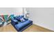 Bedroom featuring a blue chaise lounge, throw pillows, and a window for natural light at 3215 Banyan Hill Ln, Land O Lakes, FL 34639