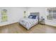 Cozy bedroom featuring natural light, a comfortable bed, and a mirrored nightstand at 3215 Banyan Hill Ln, Land O Lakes, FL 34639
