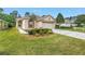 Charming single-story home featuring a manicured lawn, landscaped garden beds, and a spacious driveway at 3215 Banyan Hill Ln, Land O Lakes, FL 34639