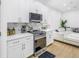 Bright kitchen with white cabinetry, stainless steel appliances, and view into living area at 3215 Banyan Hill Ln, Land O Lakes, FL 34639