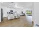 Open concept living and kitchen area with hardwood floors, bar seating, and bright natural light at 3215 Banyan Hill Ln, Land O Lakes, FL 34639