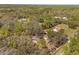Aerial view of a home nestled among trees featuring a screened pool and solar panels at 35128 Excalibur Rd, Webster, FL 33597